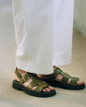 Sandales en cuir tannage végétal certifié. Vert olive dans les pieds d'une femme en pantalon blanc